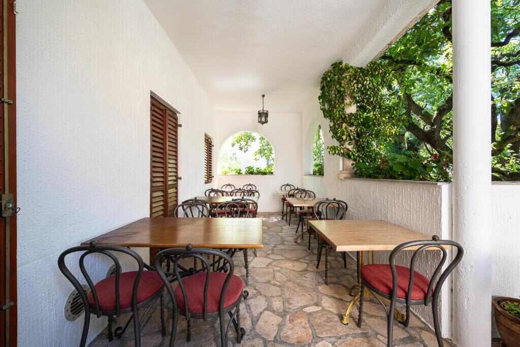 Shaded breakfast terrace with tables at Hotel Dubrava